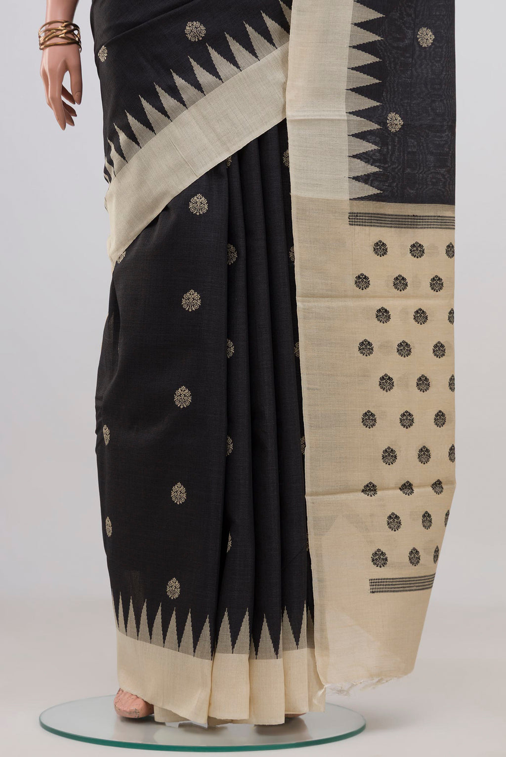 Pleats and pallu of Black Tussar Silk Saree with Thread Butta on the body and Temple Border. 