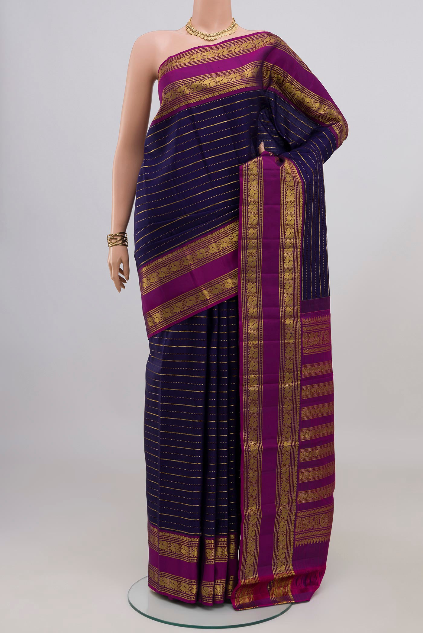 Navy Blue Kanchipuram Silk Saree with Stripes on the body and Zari Border.  displayed on a mannequin