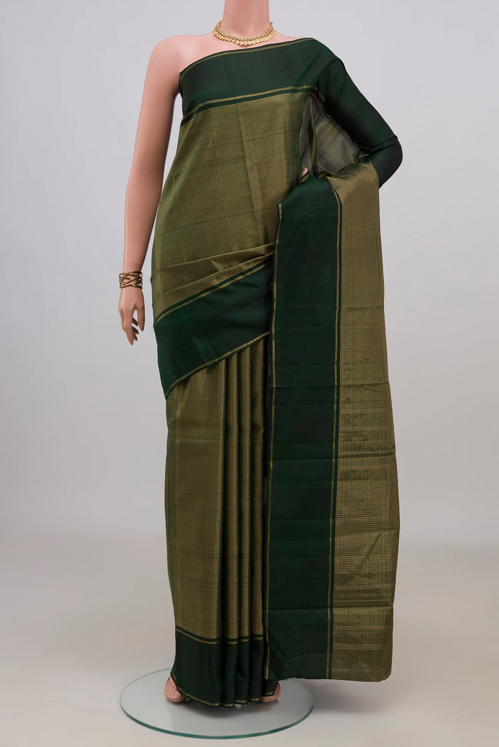 Pure Silk Bottle Green Kanchipuram Saree with Checked design on the body and Thin Zari Line.  displayed on a mannequin