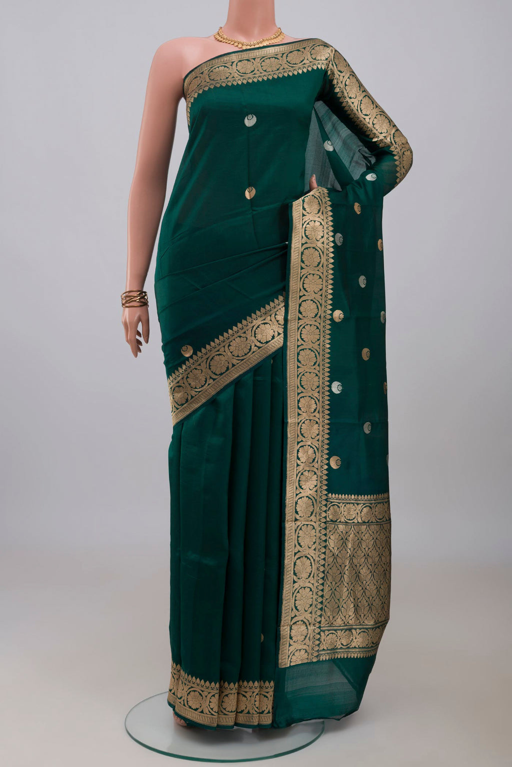 Bottle Green Banarasi Katan Silk Saree with Zari Butta on the body and Zari Border.  displayed on a mannequin