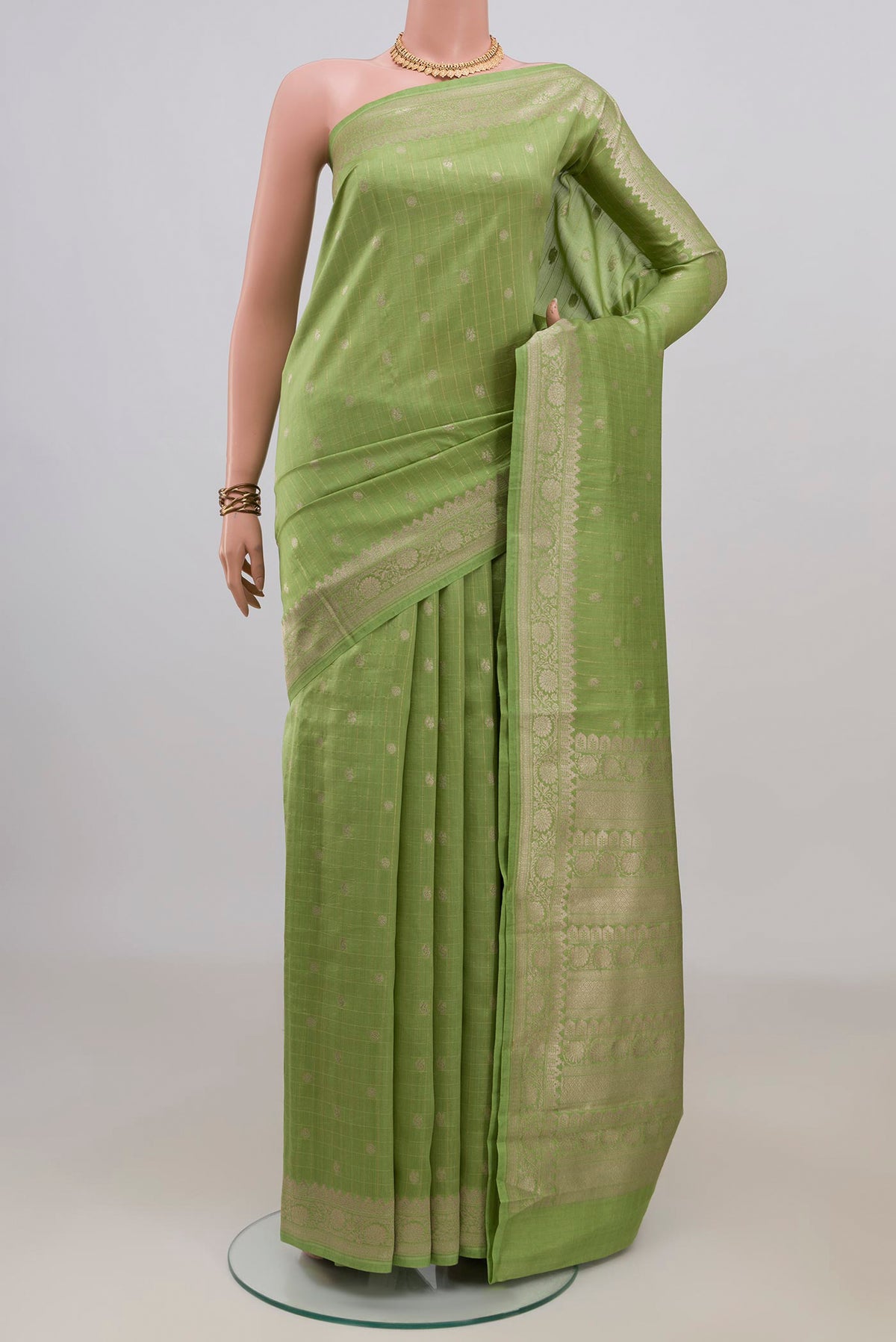 Pure Silk Pista Green Tussar Saree with Stripes on the body and Zari Border.  displayed on a mannequin