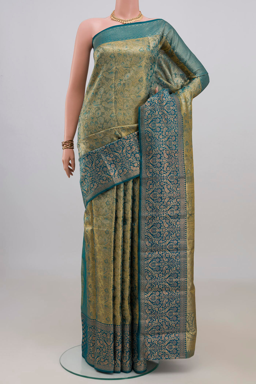 Gold with Blue Color Kanchipuram Tissue Saree with Zari Brocade on the body and Fancy Border.  displayed on a mannequin