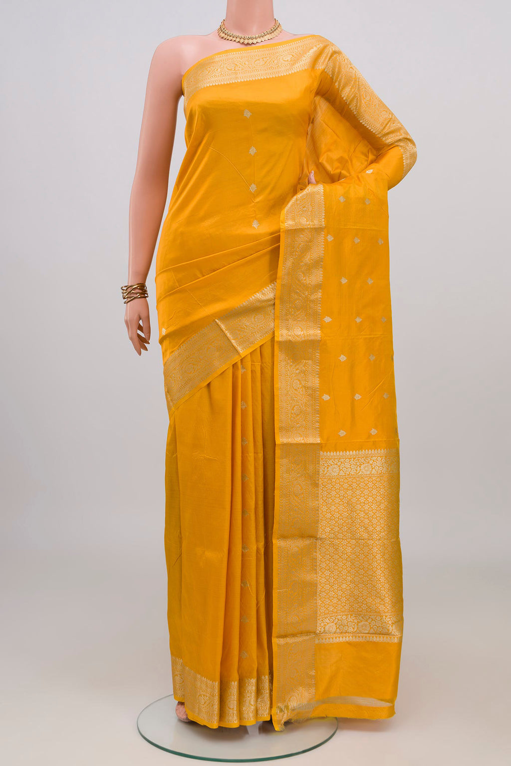 Yellow Banarasi Katan Silk Saree with Zari Butta on the body and Zari Border.  displayed on a mannequin