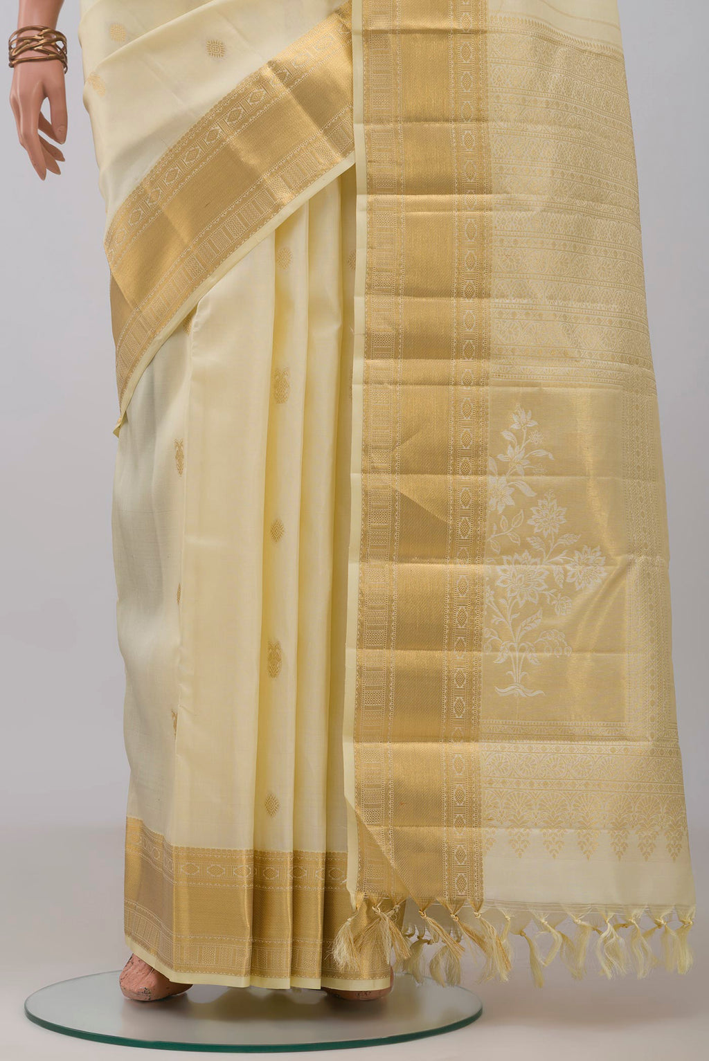 Pleats and pallu of Cream Kanchipuram Silk Saree with Zari Butta on the body and Zari Border. 