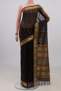 Black Silk Cotton Saree with Stripes on the body and Zari Border.  displayed on a mannequin