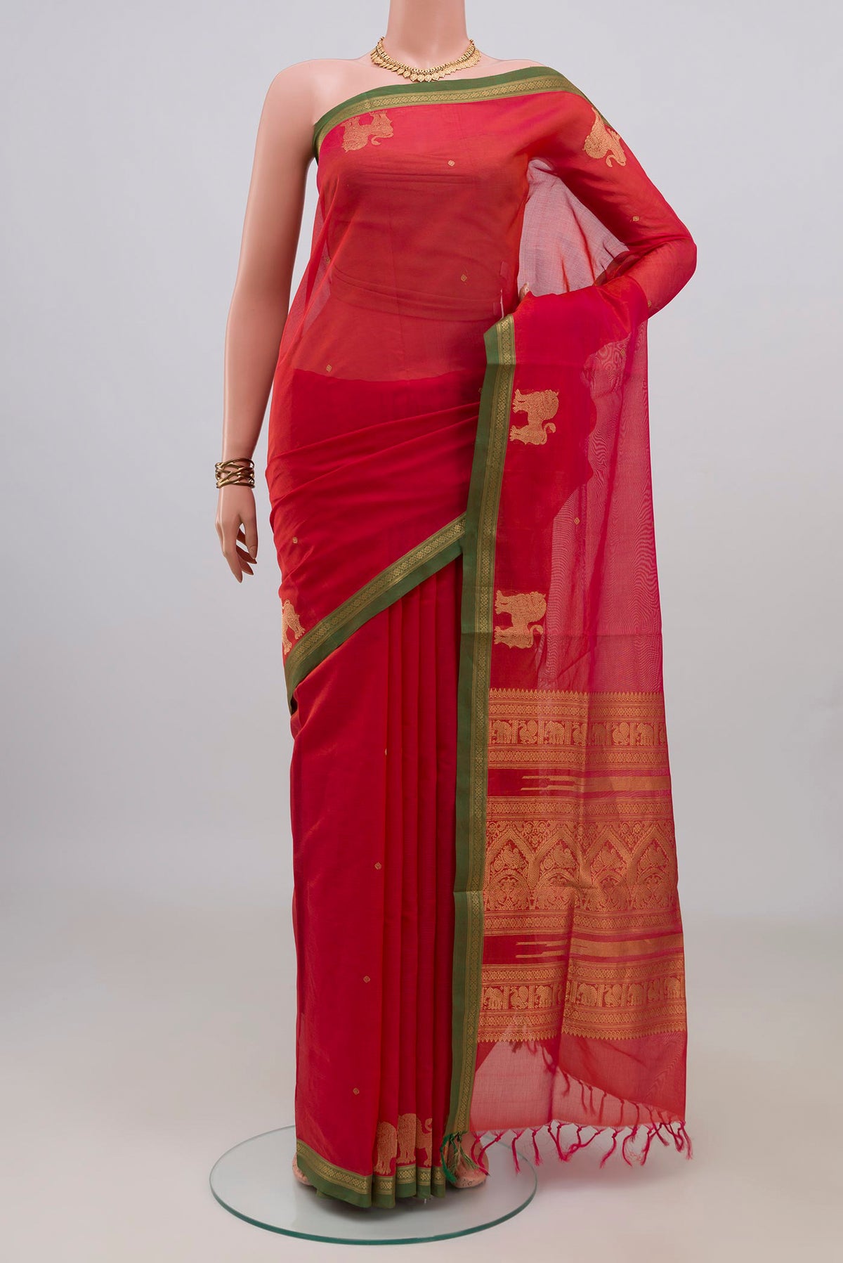 Orange Silk Cotton Saree with Zari Butta on the body and Zari Border.  displayed on a mannequin