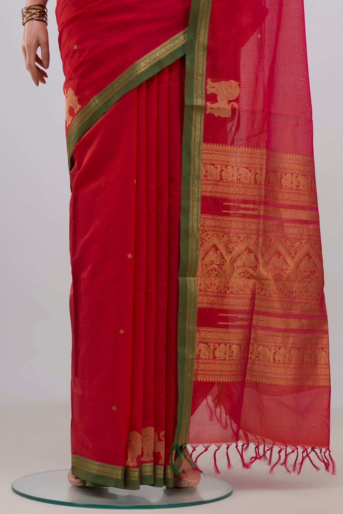 Pleats and pallu of Orange Silk Cotton Saree with Zari Butta on the body and Zari Border. 
