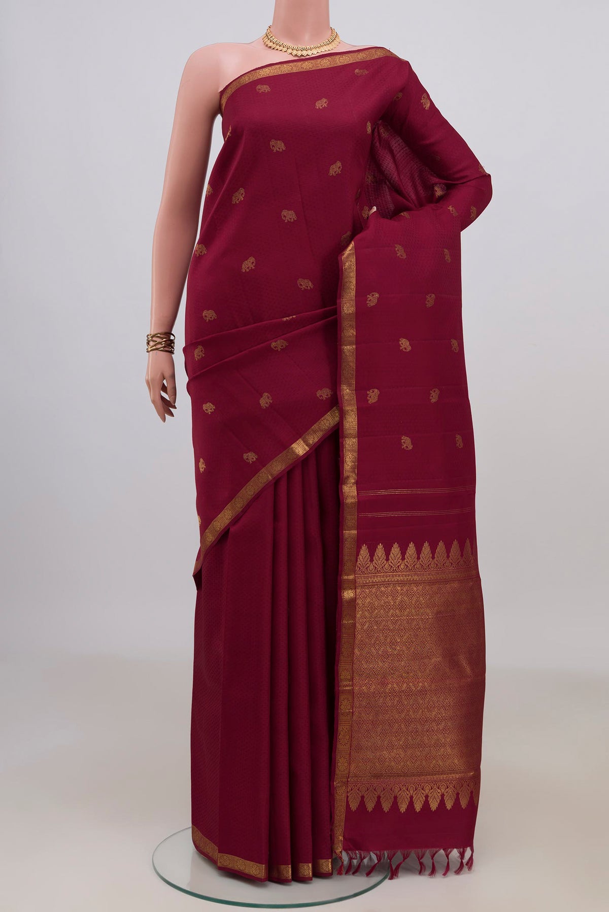 Pure Silk Maroon Kanjivaram Saree with Jacquard With Zari Butta on the body and Zari Border.  displayed on a mannequin