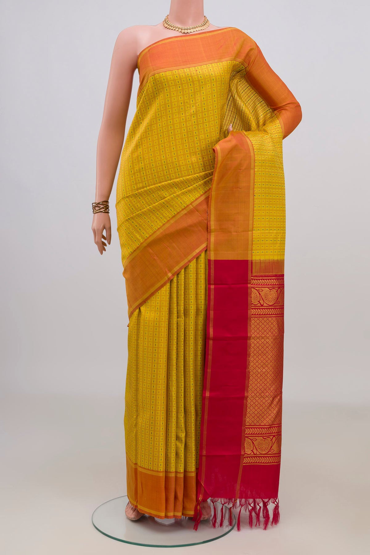 Pure Silk Yellow Kanchipuram Saree with Checked design on the body and Zari Border.  displayed on a mannequin