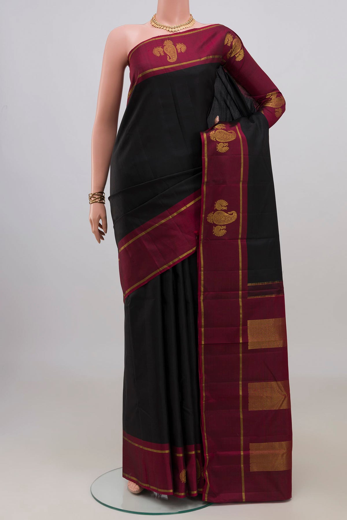 Pure Silk Black Kanchipuram Saree with Plain Body and Fancy Border.  displayed on a mannequin