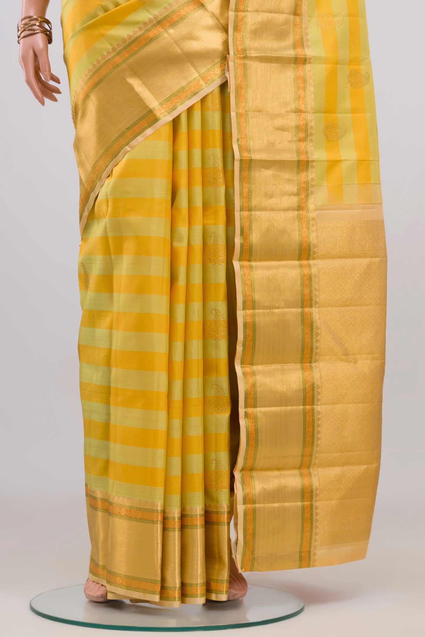 Pleats and pallu of Yellow Kanjivaram Silk Saree with Stripes on the body and Zari Border. 