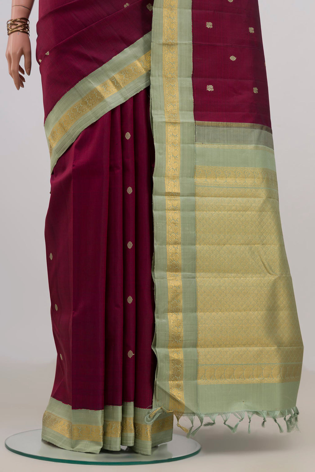 Pleats and pallu of Pure Silk Maroon Kanjivaram Saree with Thread Butta on the body and Zari Border. 