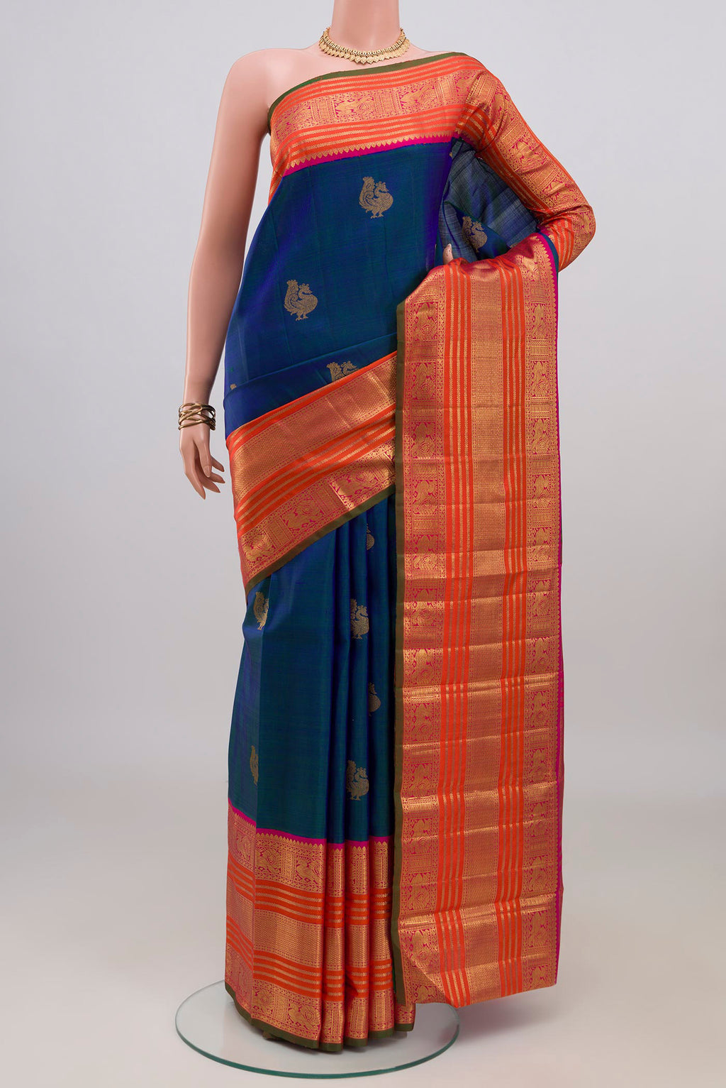 Pure Silk Pure Zari Peacock Blue Kanchipuram Saree with Zari Butta on the body and Zari Border.  displayed on a mannequin