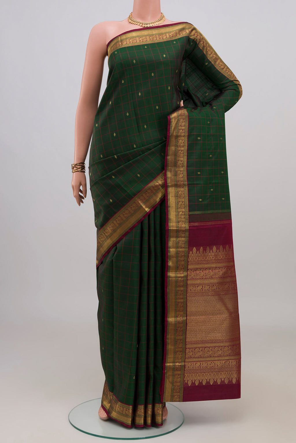 Pure Silk Pure Zari Bottle Green Kanjivaram Saree with Checked design on the body and Zari Border.  displayed on a mannequin