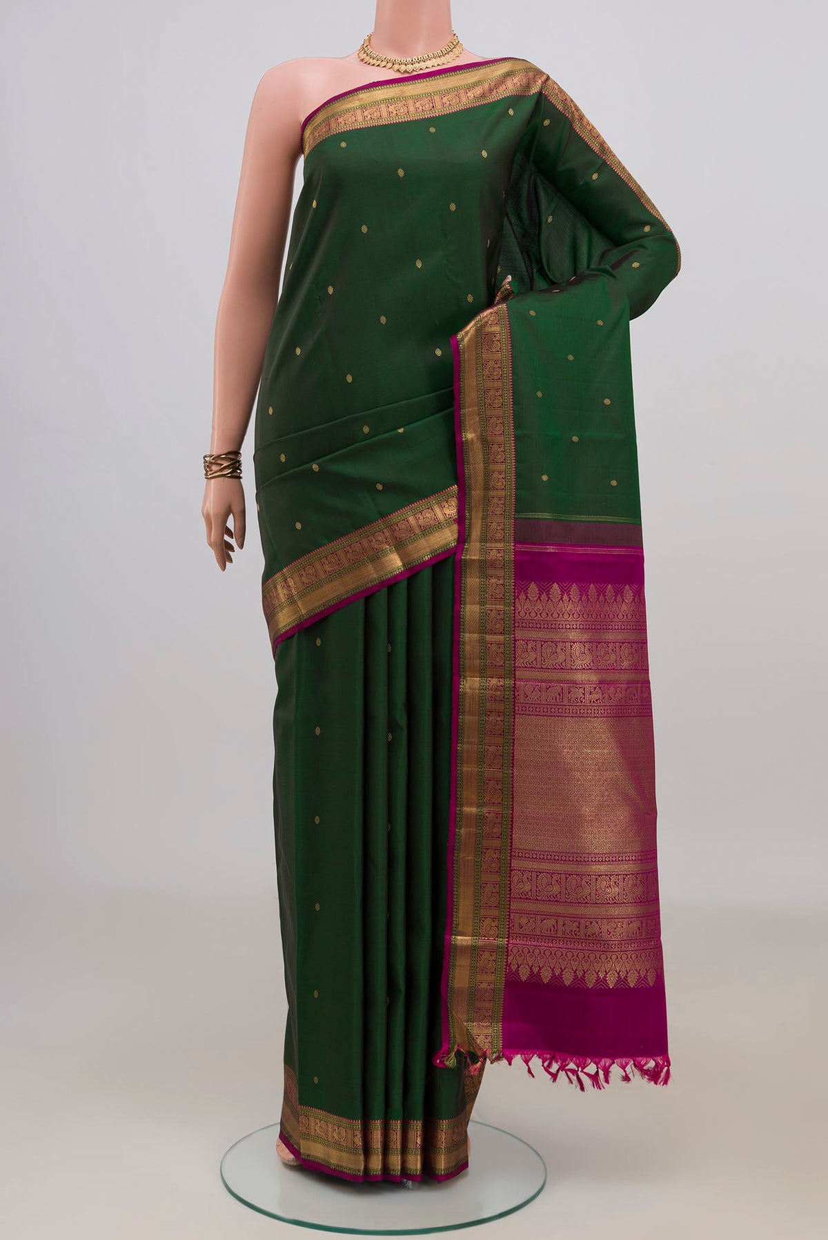 Pure Silk Pure Zari Bottle Green Kanjivaram Saree with Zari Butta on the body and Zari Border.  displayed on a mannequin
