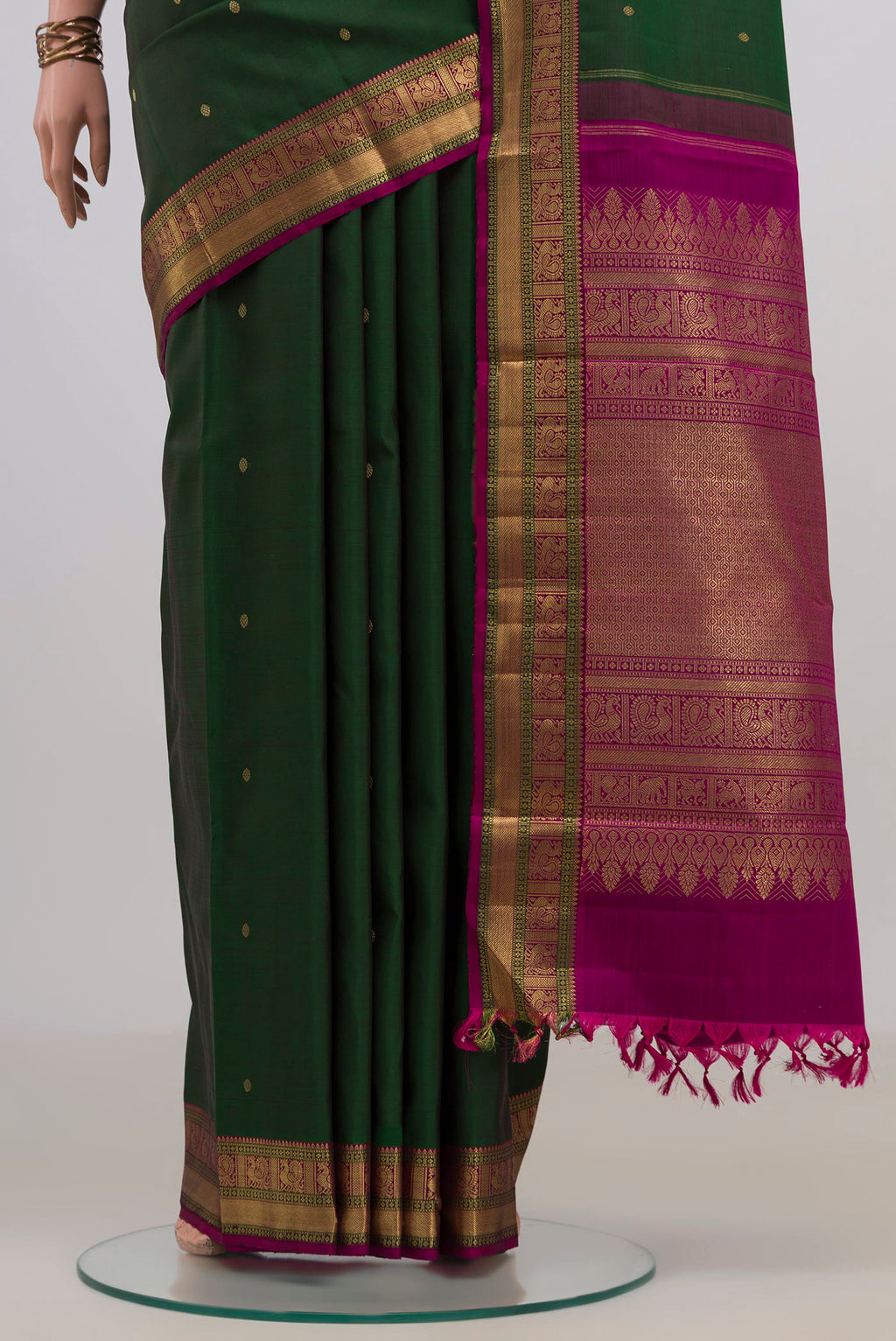 Pleats and pallu of Pure Silk Pure Zari Bottle Green Kanjivaram Saree with Zari Butta on the body and Zari Border. 
