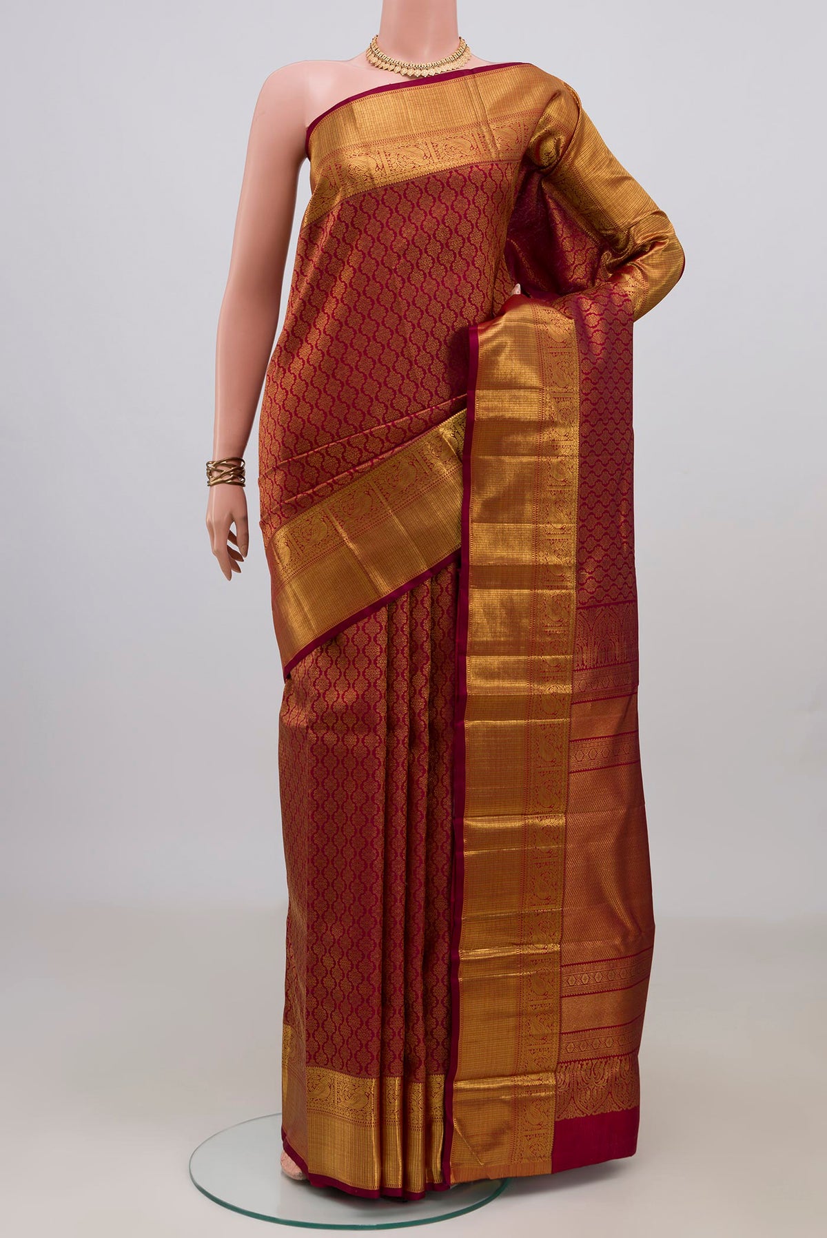 Pure Silk Maroon Kanchipuram Saree with Zari Brocade on the body and Zari Border.  displayed on a mannequin