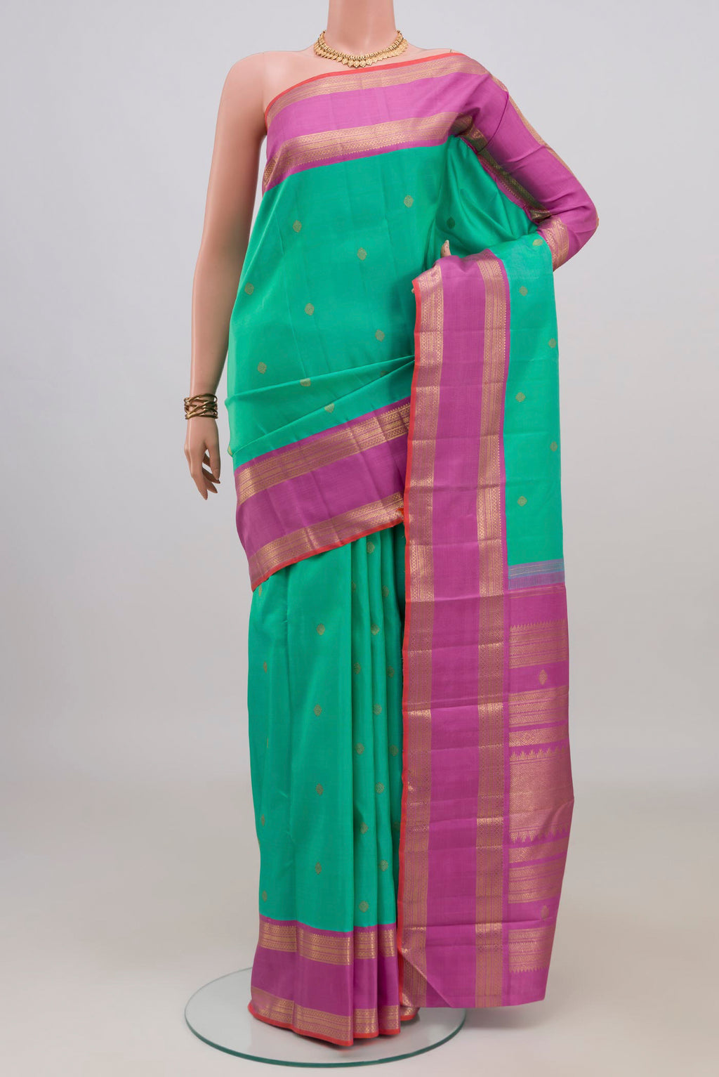 Pure Silk Pure Zari Green Kanjivaram Saree with Zari Butta on the body and Zari Border.  displayed on a mannequin