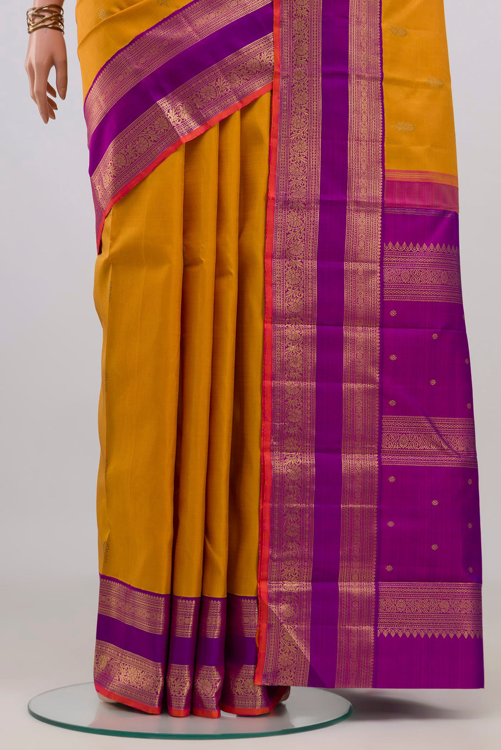 Pleats and pallu of Pure Silk Pure Zari Mustard Kanjivaram Saree with Zari Butta on the body and Zari Border. 