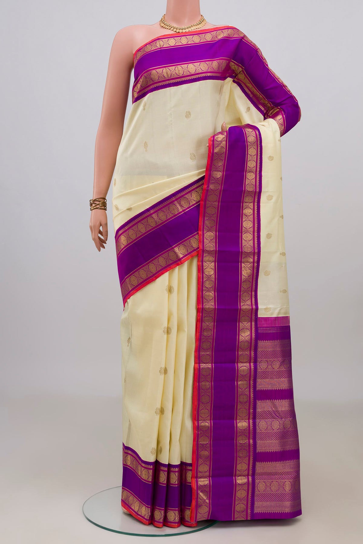 Pure Silk Pure Zari Off White Kanjivaram Saree with Zari Butta on the body and Zari Border.  displayed on a mannequin
