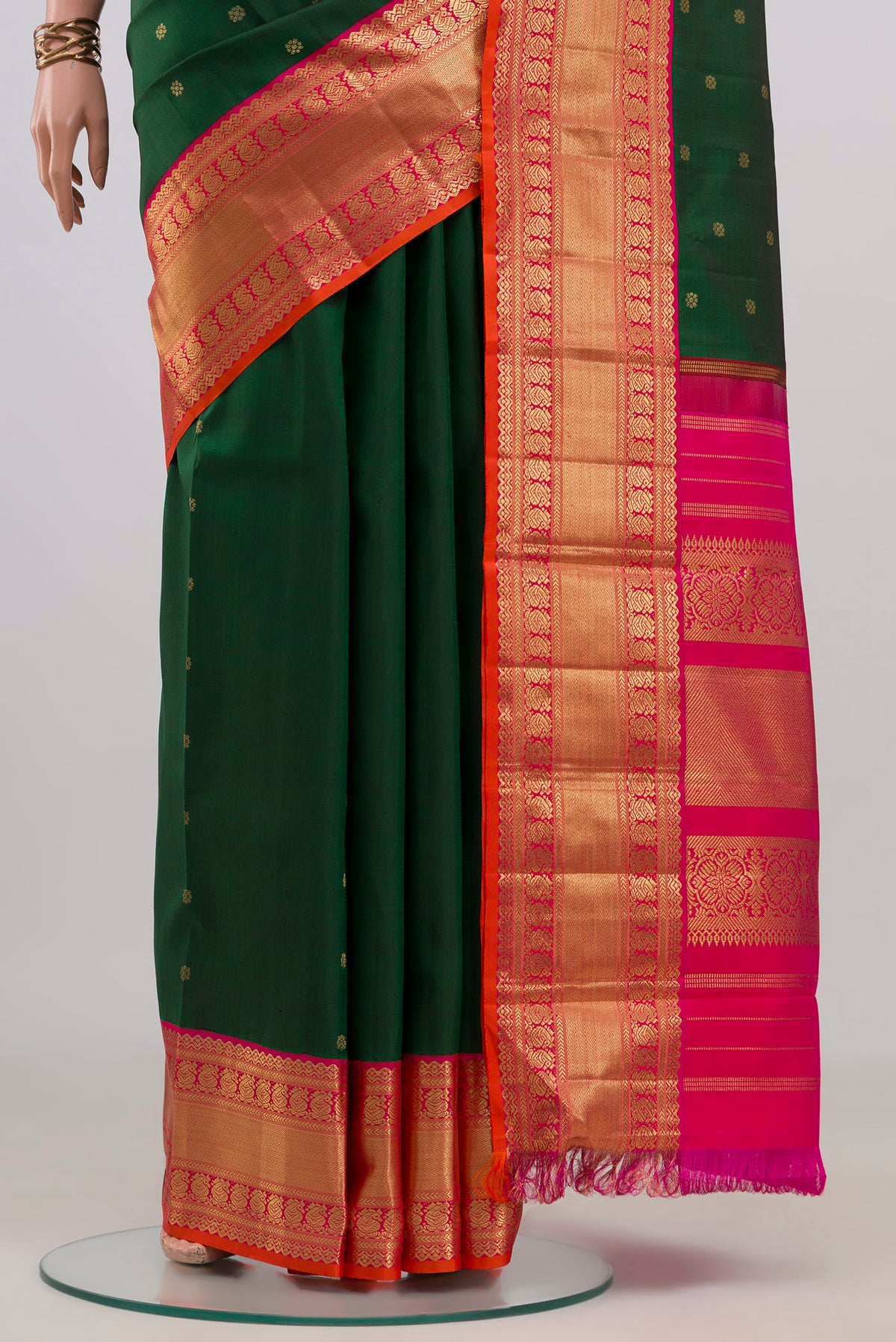 Pleats and pallu of Pure Silk Pure Zari Bottle Green Kanjivaram Saree with Zari Butta on the body and Zari Border. 