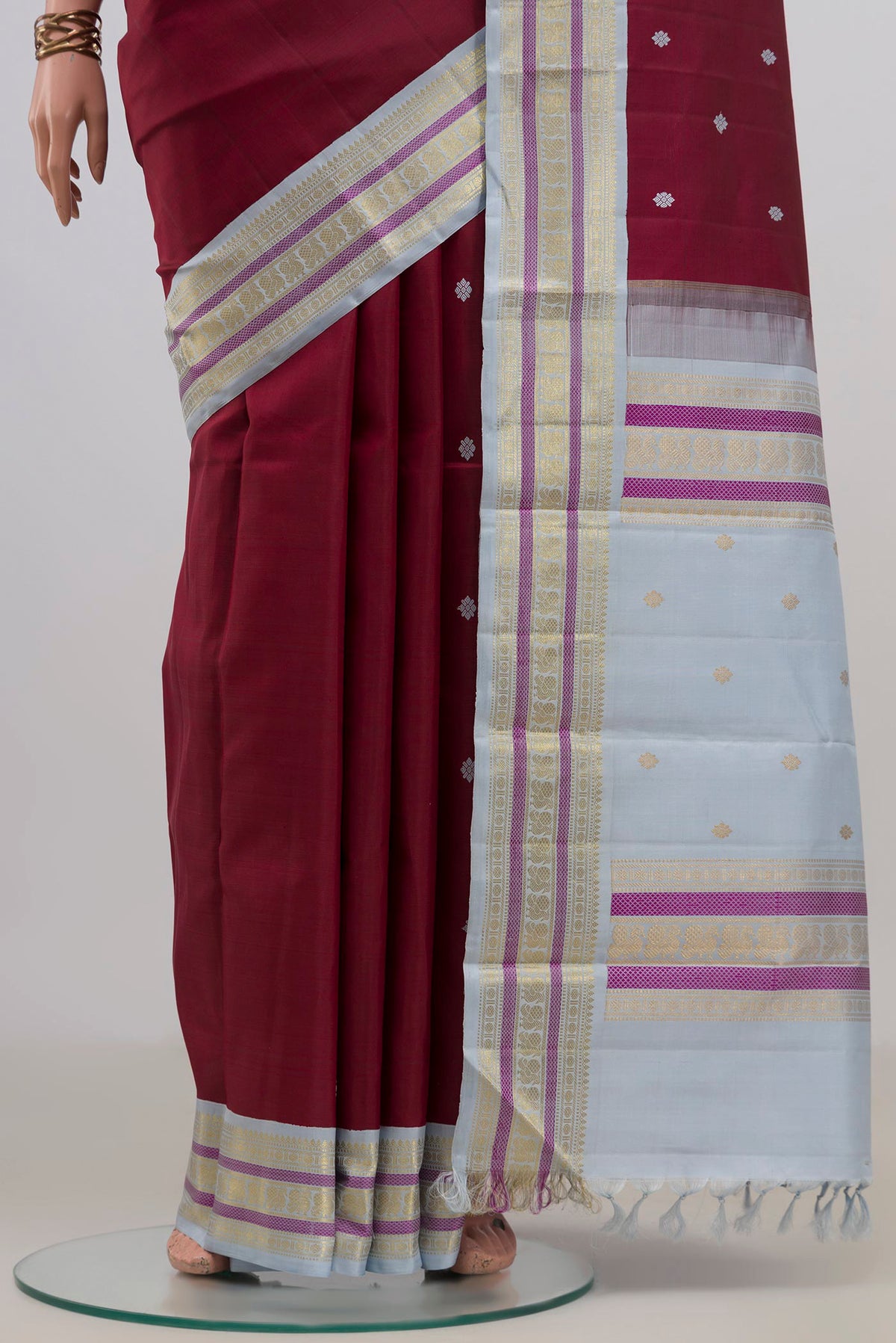 Pleats and pallu of Pure Silk Maroon Kanjivaram Saree with Thread Butta on the body and Zari Border. 