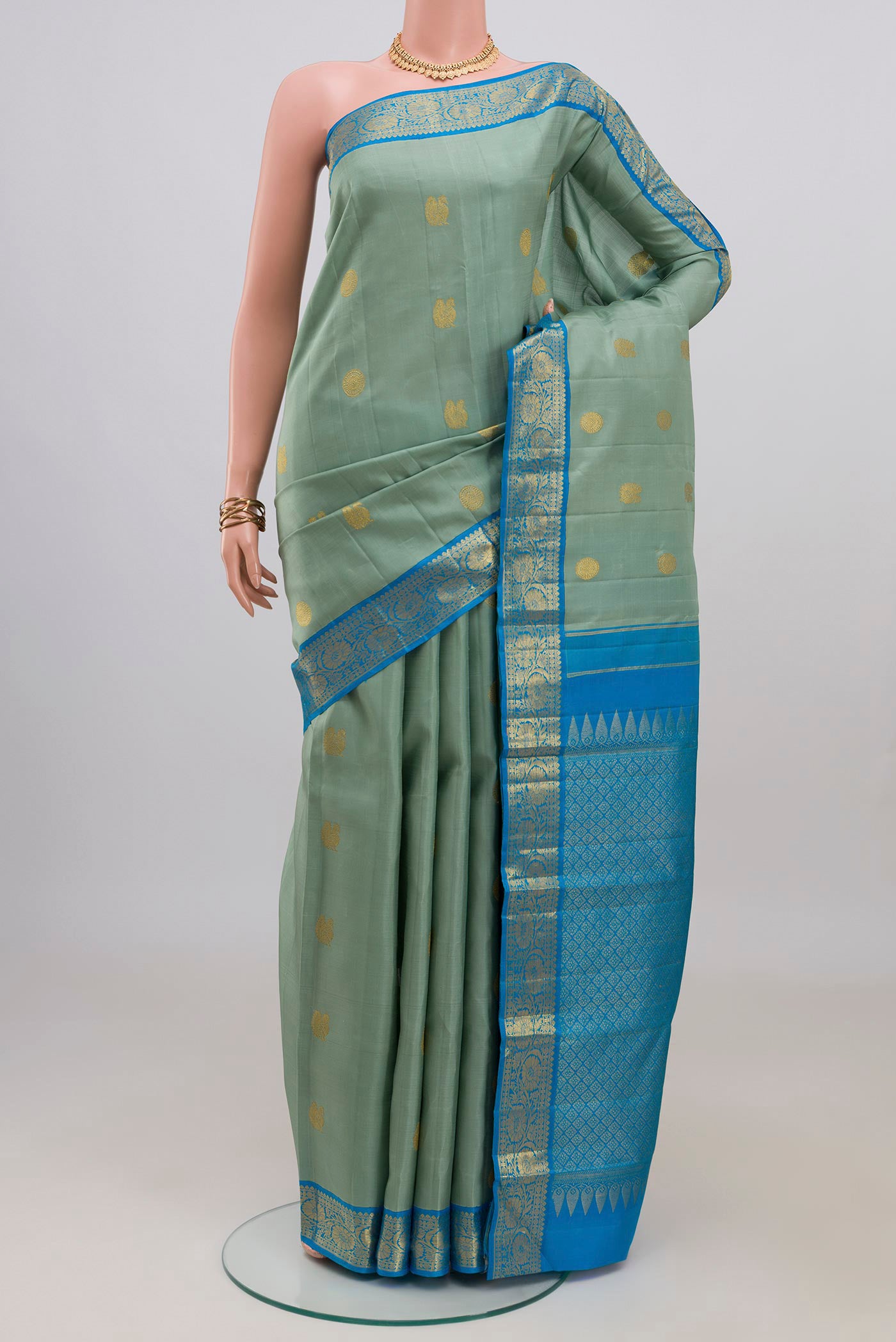 Blue Kanjivaram Silk Saree with Zari Butta on the body and Zari Border.  displayed on a mannequin