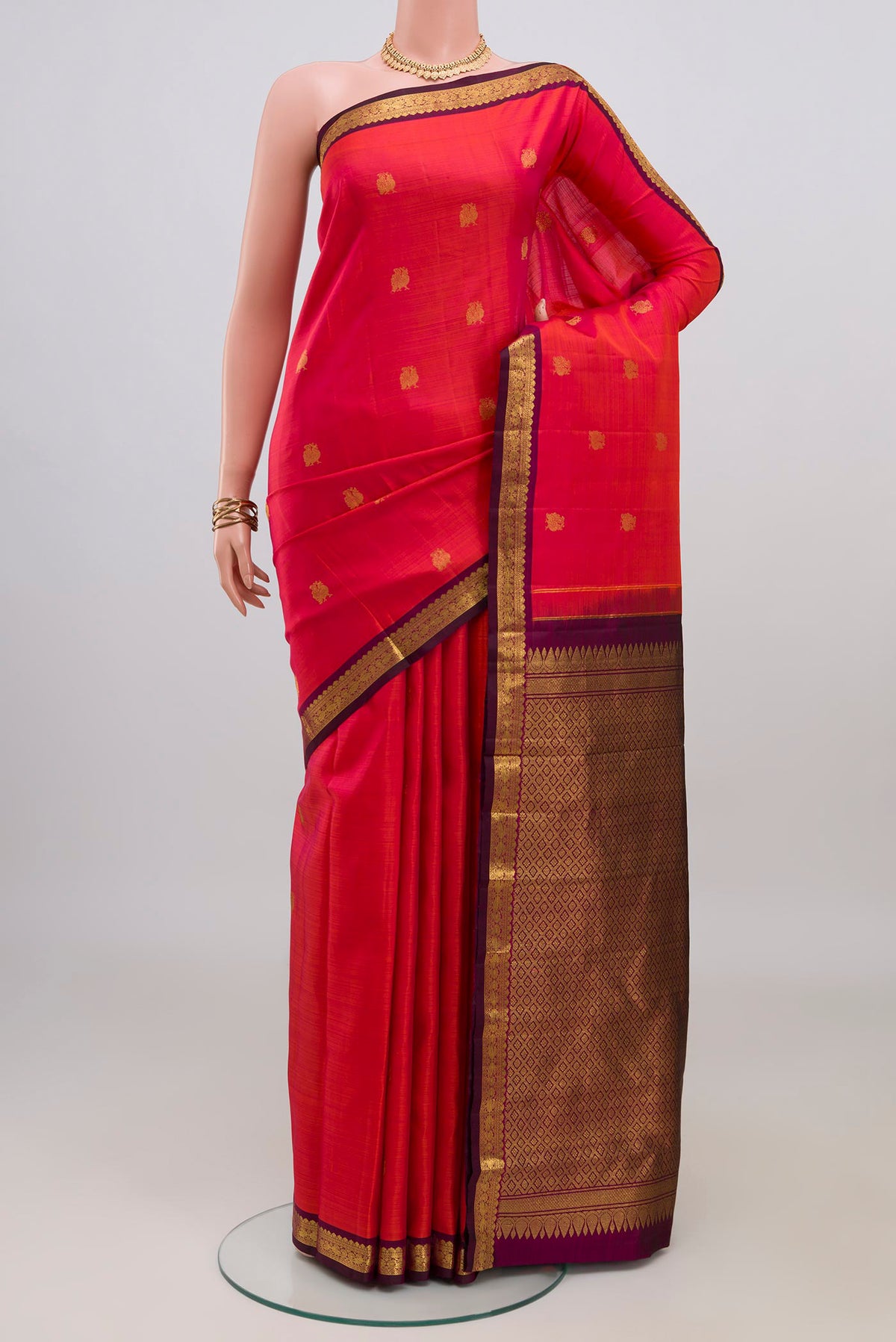 Pink Kanchipuram Silk Saree with Zari Butta on the body and Zari Border.  displayed on a mannequin