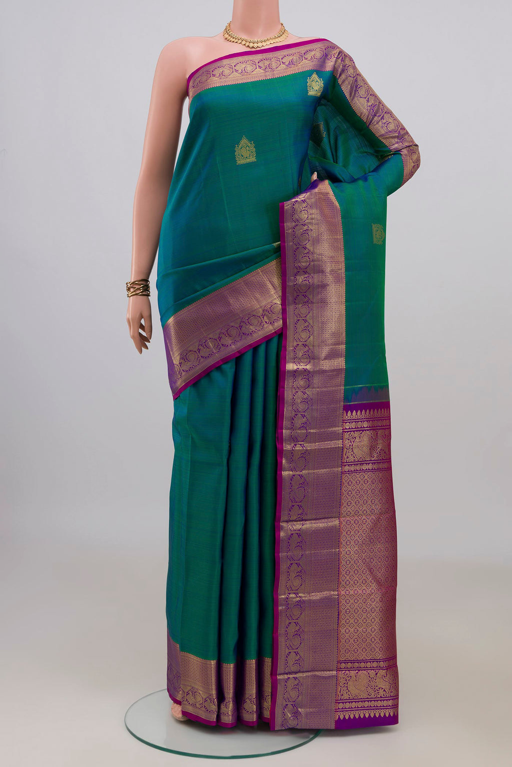 Pure Silk Peacock Blue Dual Tone Kanchipuram Saree with Zari Butta on the body and Zari Border.  displayed on a mannequin