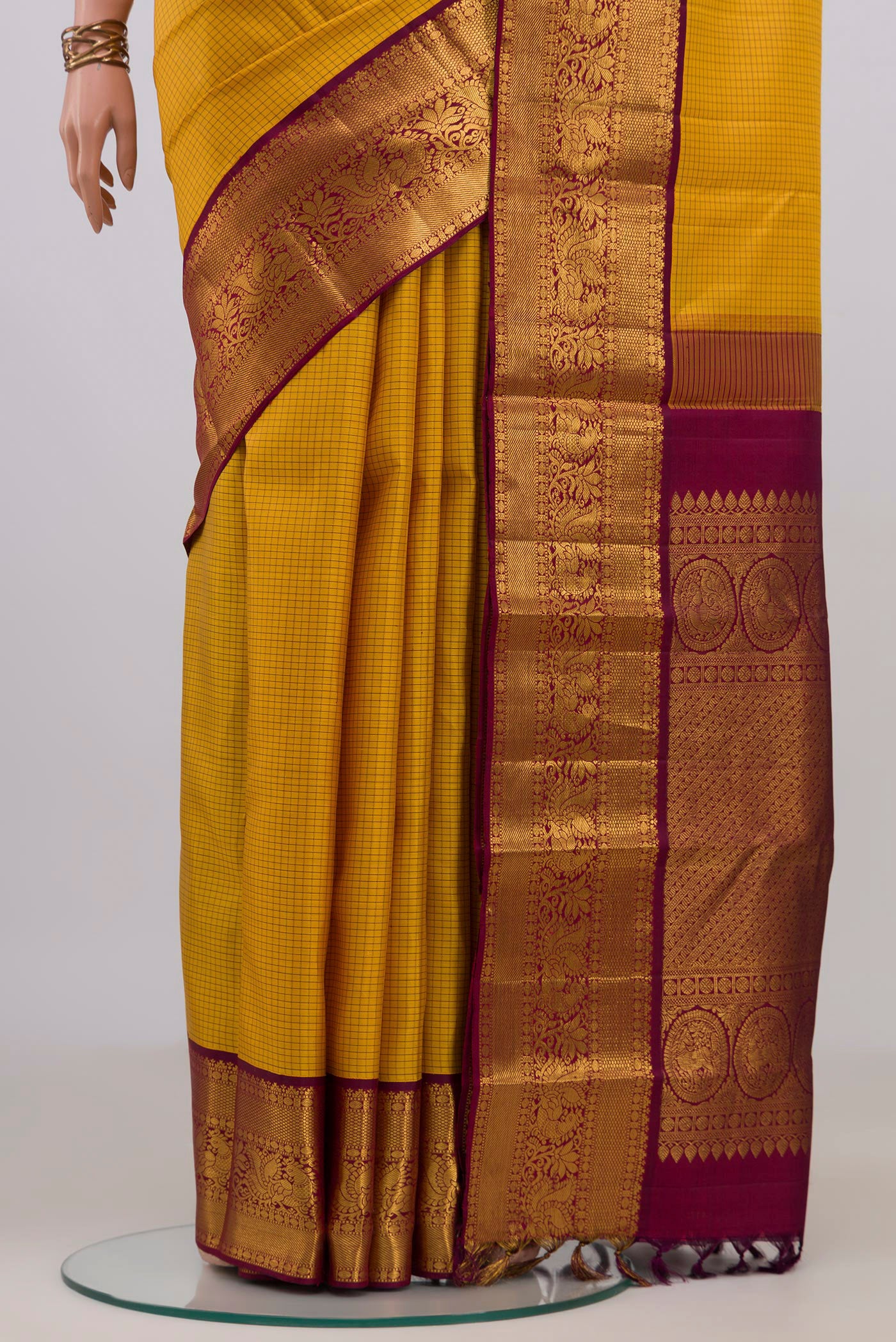 Pleats and pallu of Yellow Kanjivaram Silk Saree with Checked design on the body and Zari Border. 