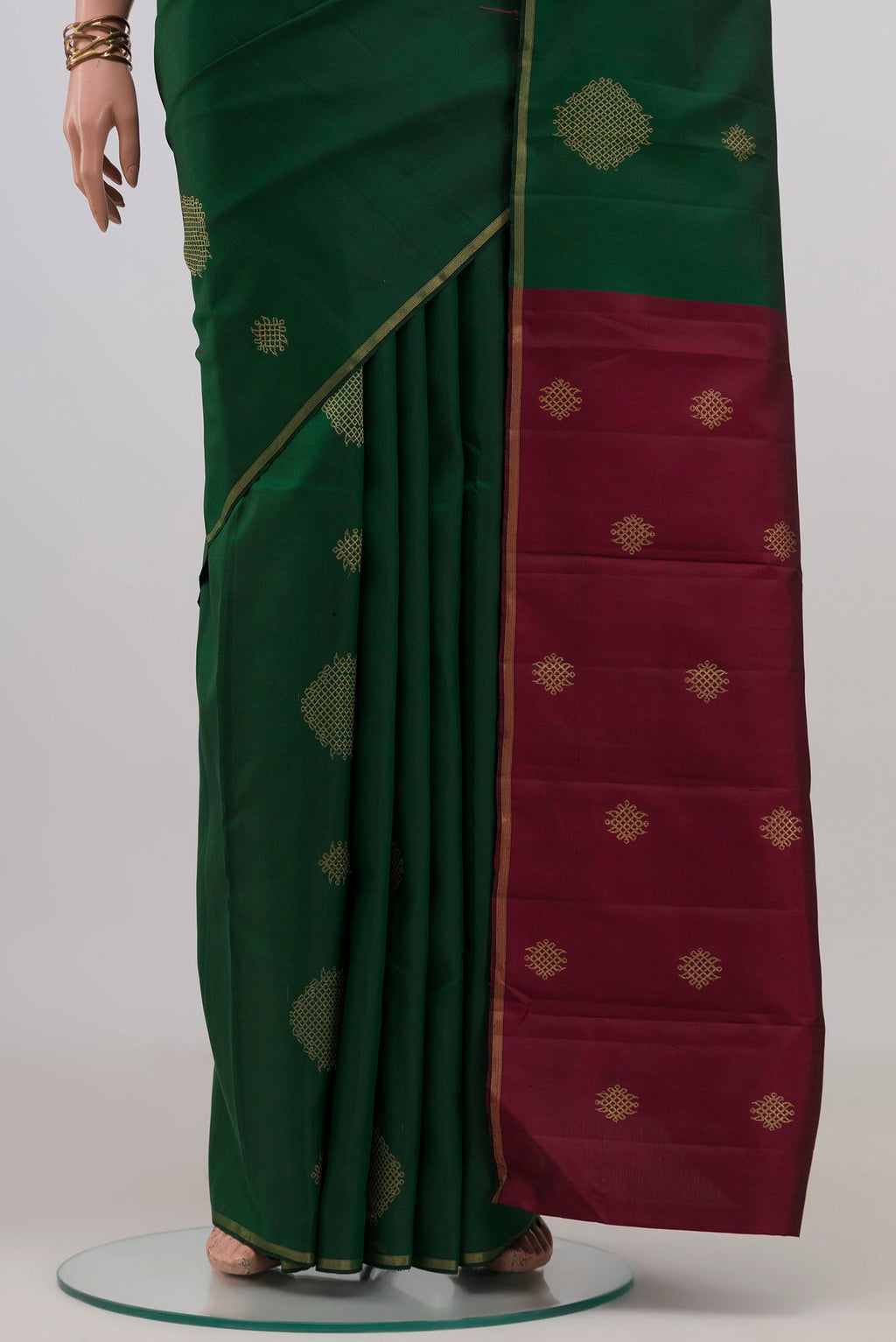 Pleats and pallu of Bottle Green Kanchipuram Silk Saree with Zari Butta on the body and Thin Zari Line. 