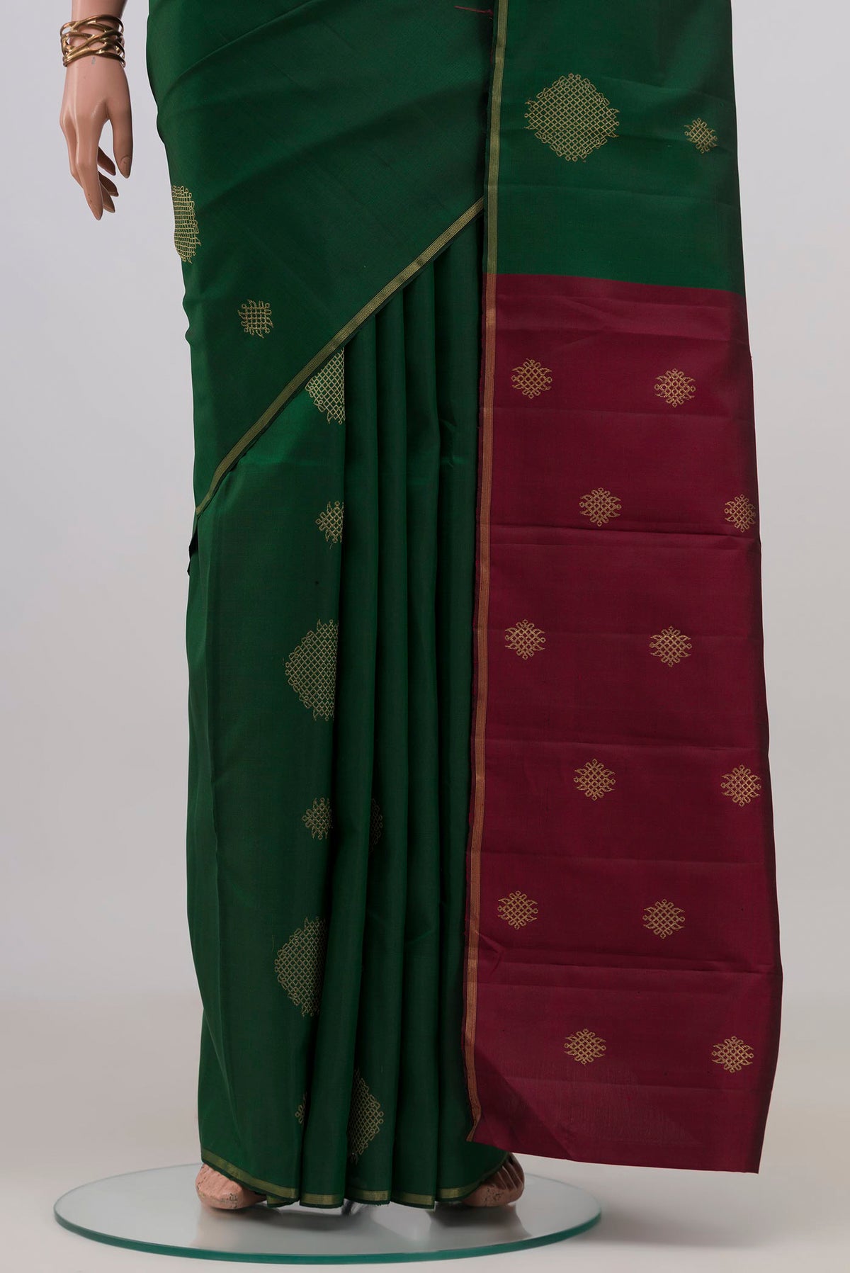 Pleats and pallu of Bottle Green Kanchipuram Silk Saree with Zari Butta on the body and Thin Zari Line. 