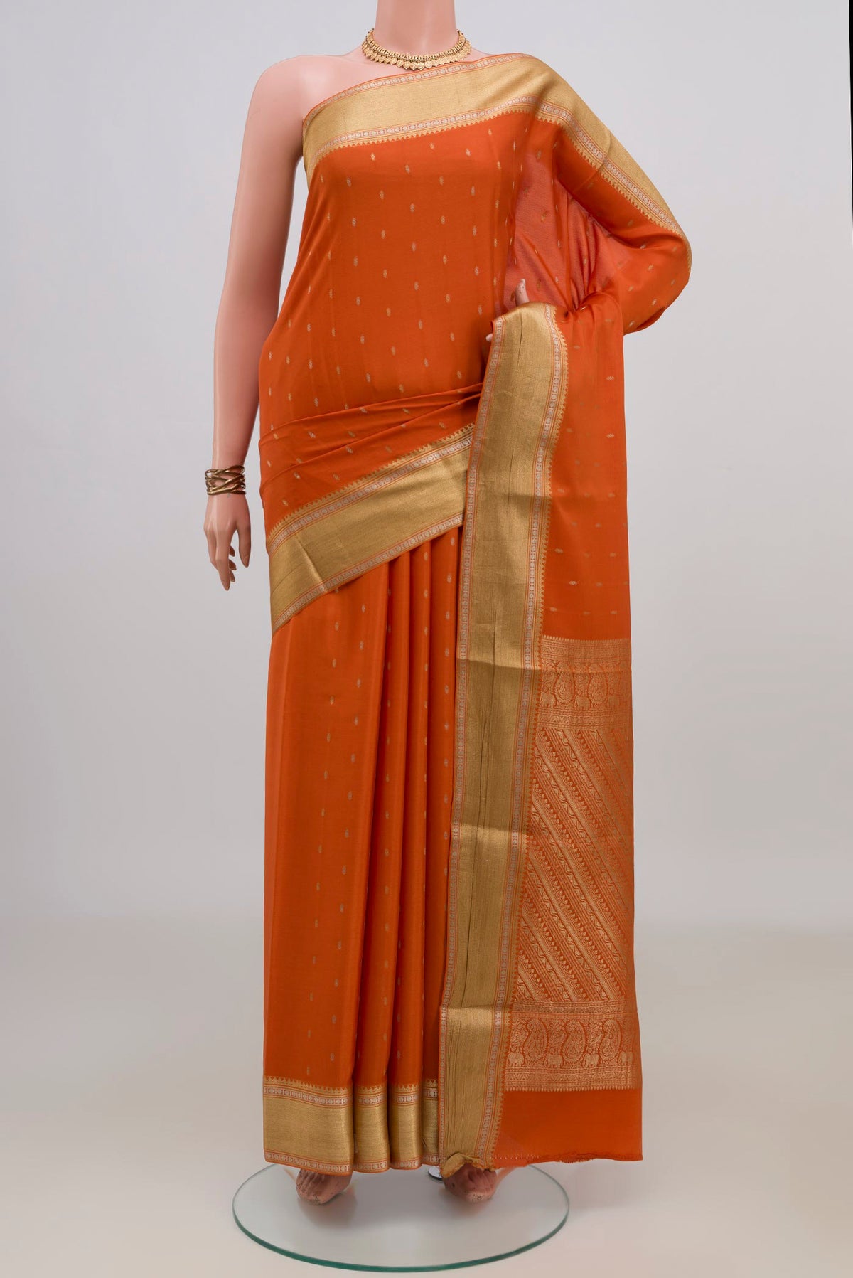 Orange Mysore Crepe Saree with Zari Butta on the body and Zari Border.  displayed on a mannequin