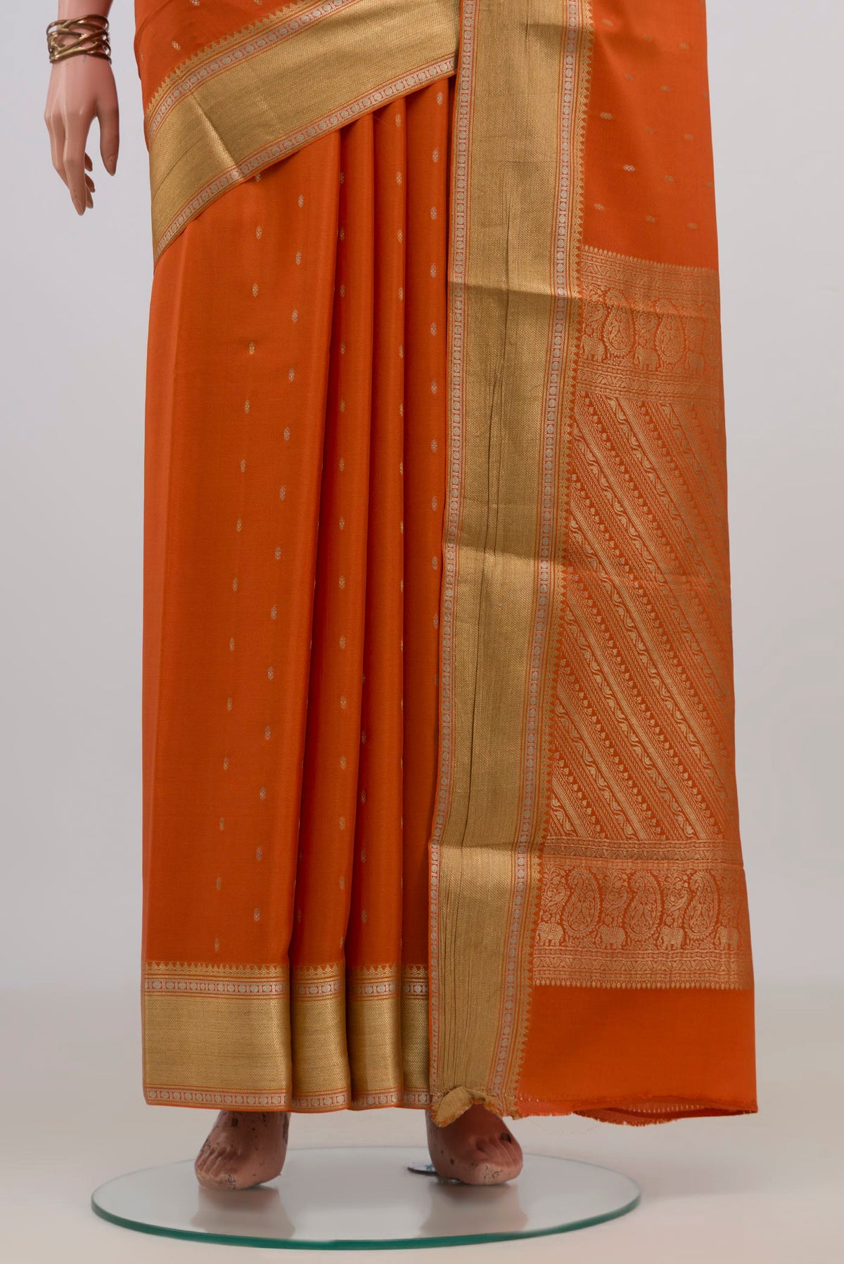 Pleats and pallu of Orange Mysore Crepe Saree with Zari Butta on the body and Zari Border. 