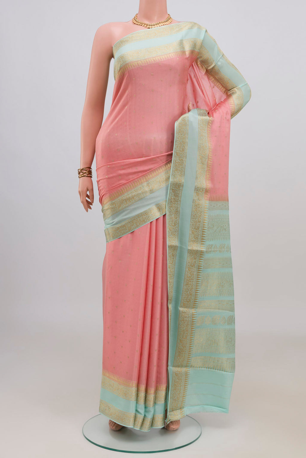 Peach Mysore Crepe Saree with Zari Butta on the body and Zari Border.  displayed on a mannequin