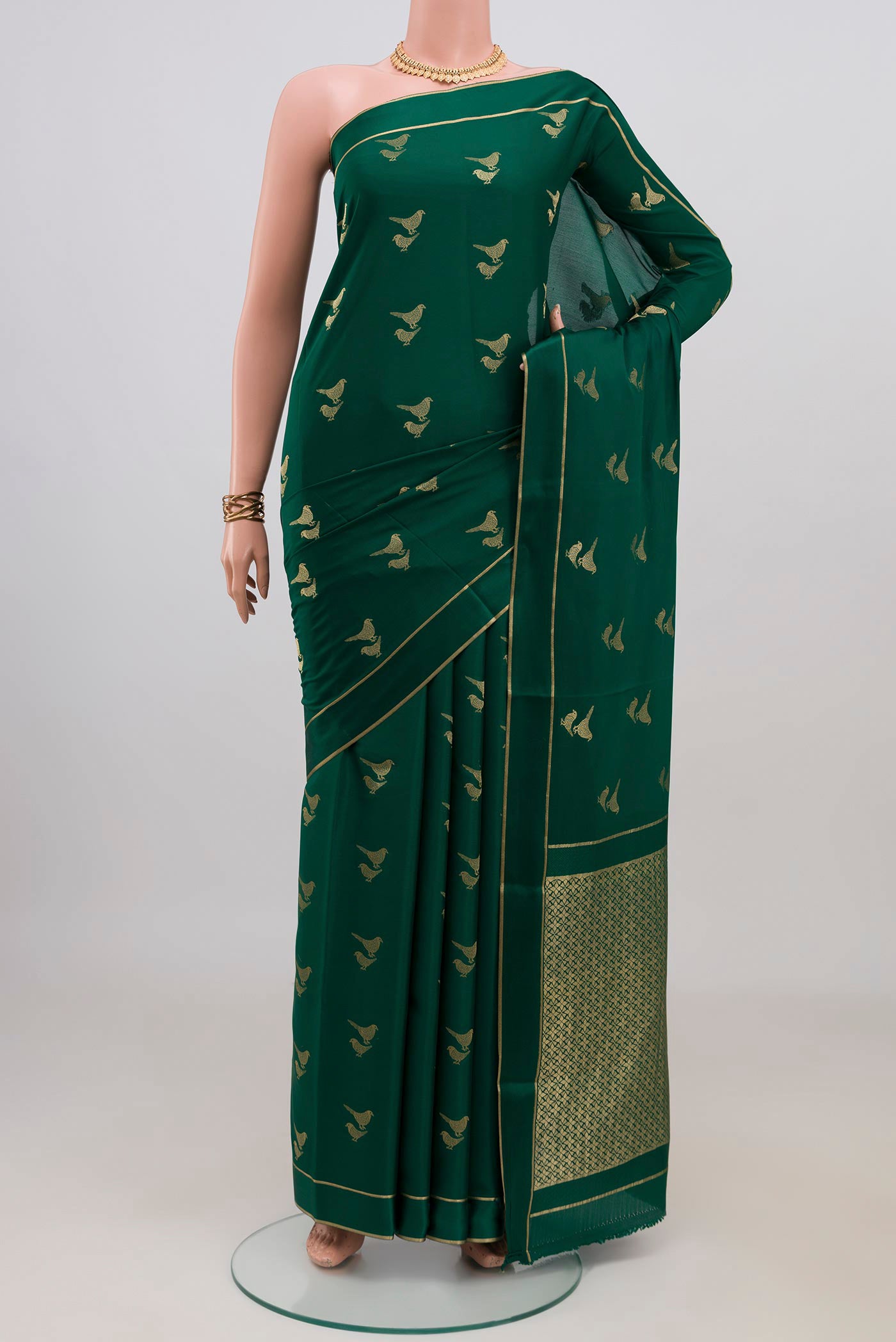 Green Mysore Crepe Saree with Zari Butta on the body and Thin Zari Line.  displayed on a mannequin