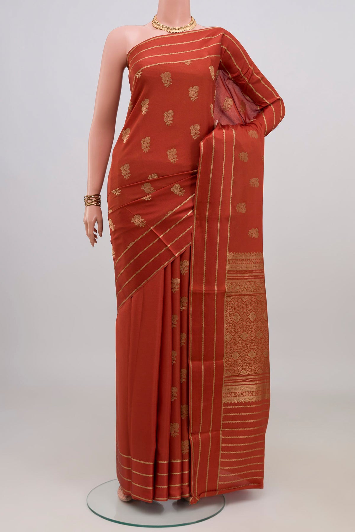 Rust Mysore Crepe Saree with Zari Butta on the body and Thin Zari Line.  displayed on a mannequin