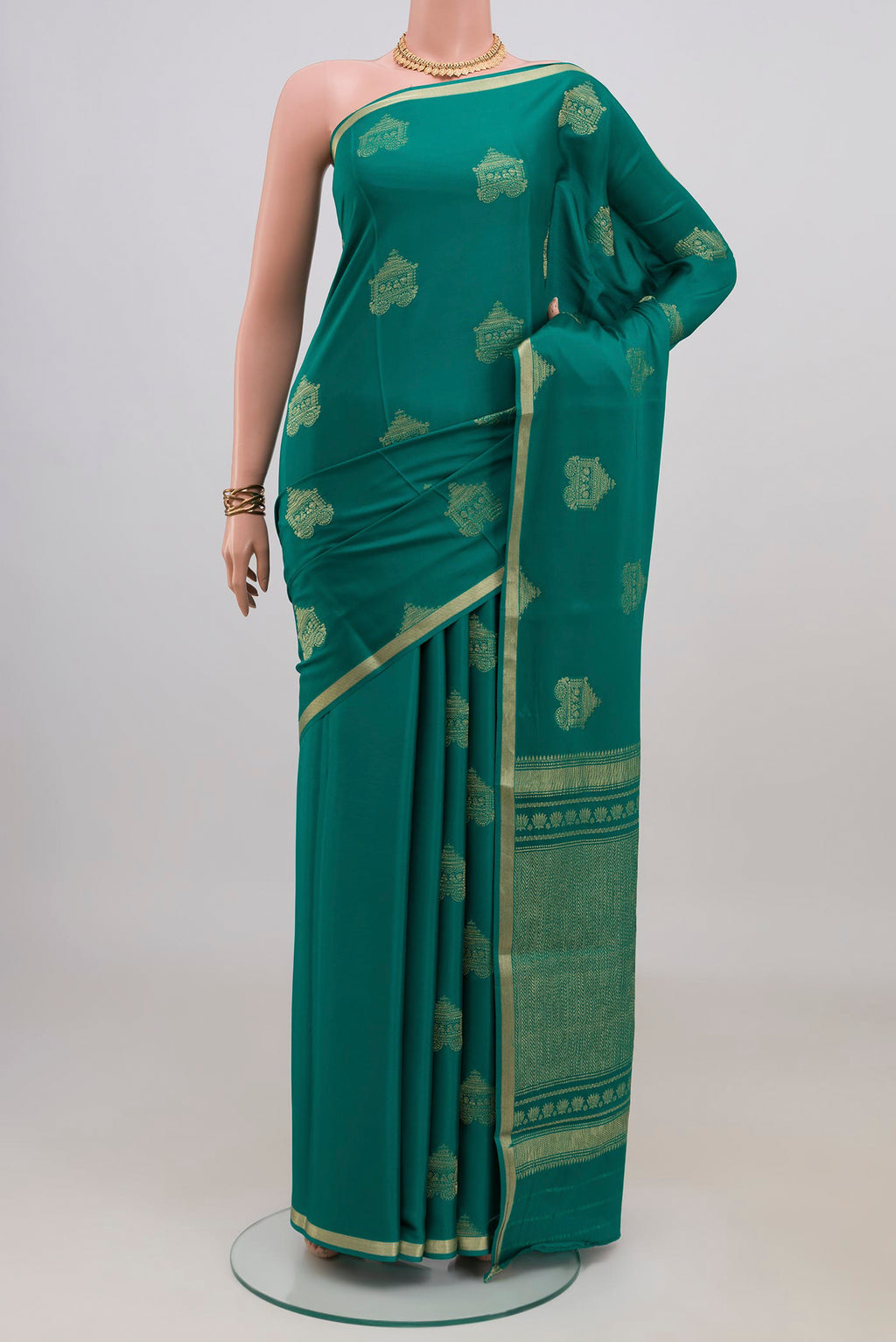 Teal Mysore Crepe Saree with Zari Butta on the body and Thin Zari Line.  displayed on a mannequin