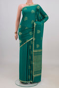Teal Mysore Crepe Saree with Zari Butta on the body and Thin Zari Line.  displayed on a mannequin