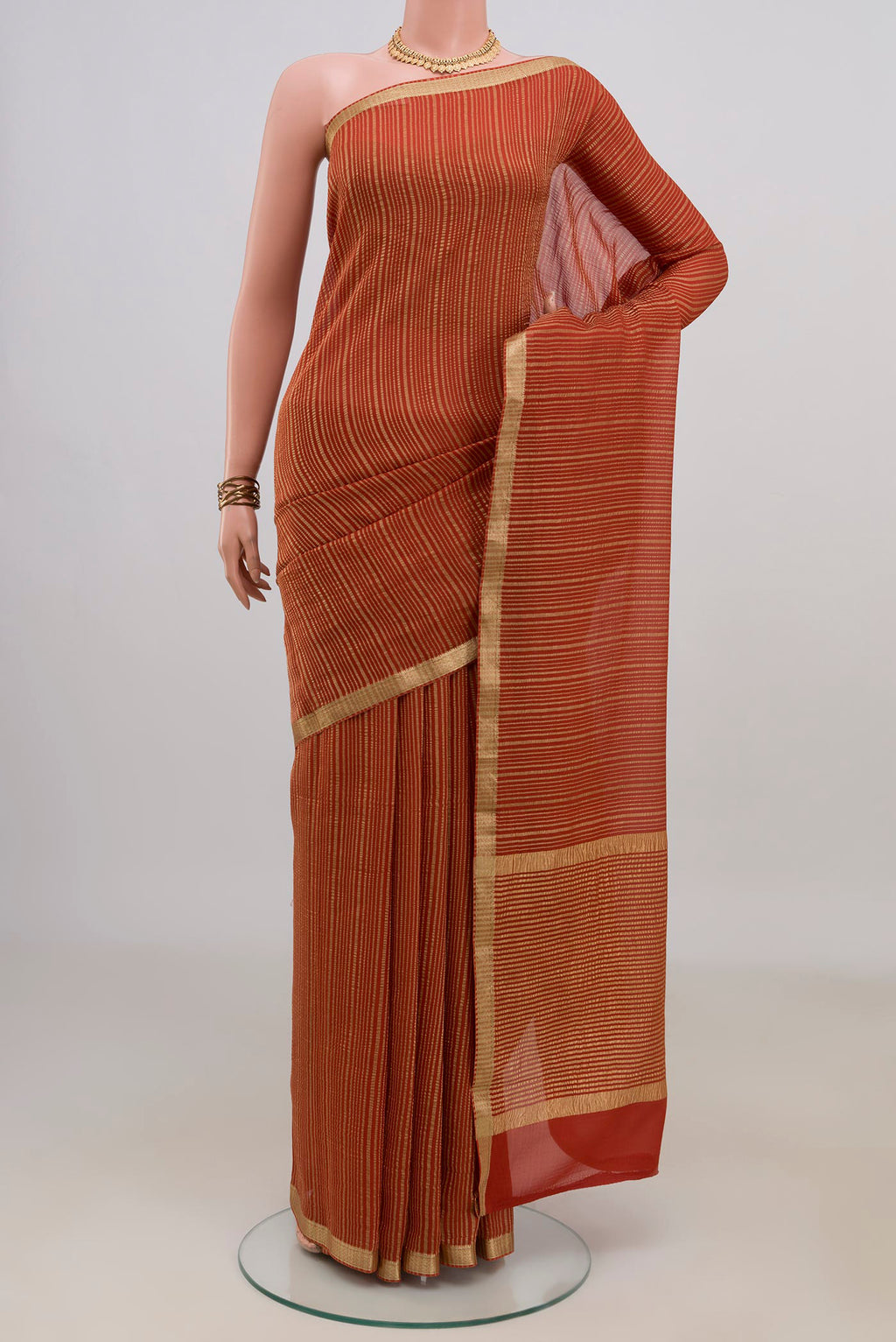 Rust Mysore Georgette Saree with Stripes on the body and Thin Zari Line.  displayed on a mannequin