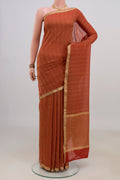 Rust Mysore Georgette Saree with Stripes on the body and Thin Zari Line.  displayed on a mannequin