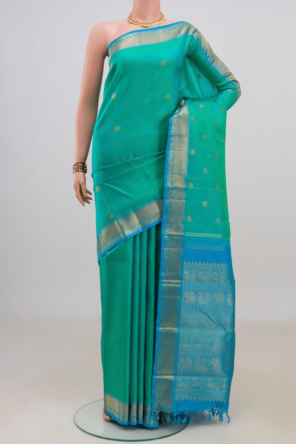 Pure Silk Pure Zari Turquoise Kanjivaram Saree with Zari Butta on the body and Zari Border.  displayed on a mannequin
