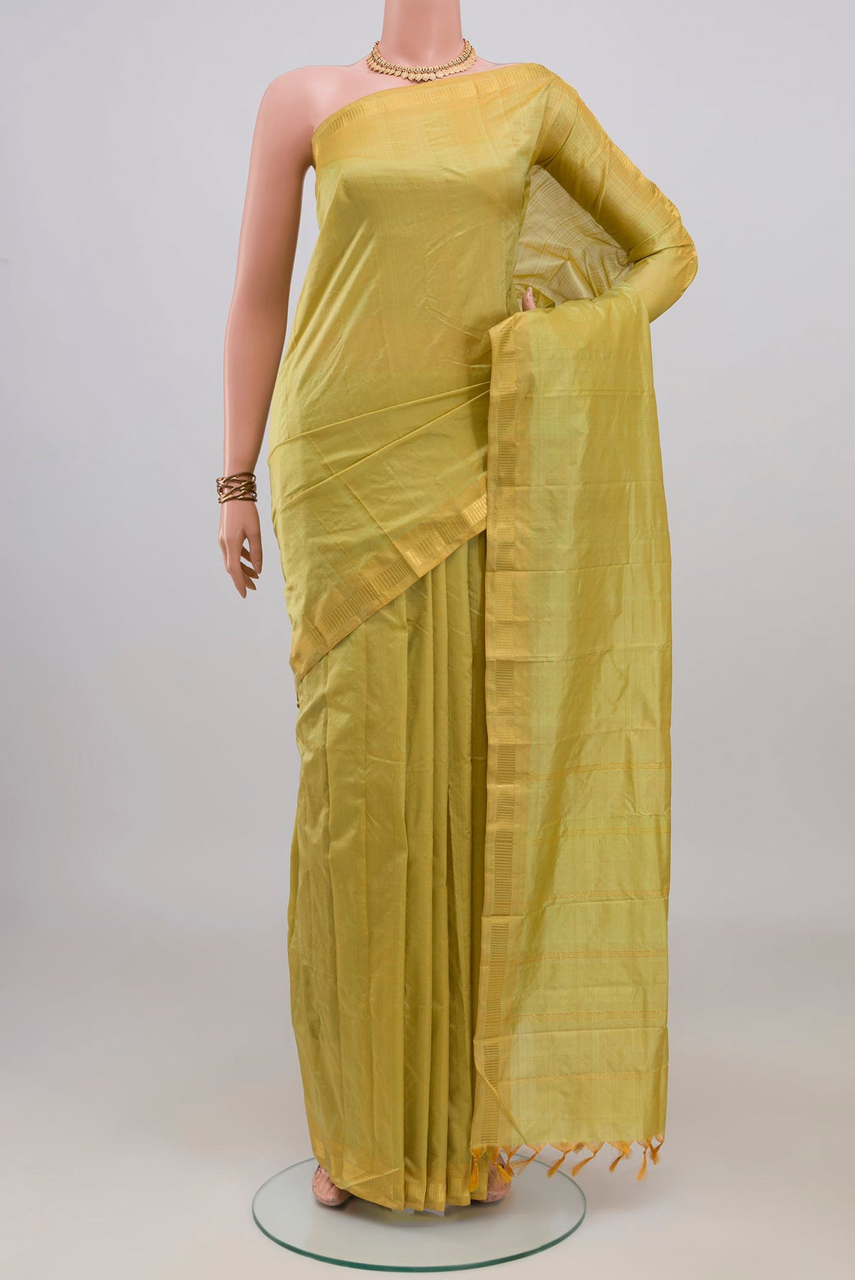 Pure Silk Green Kanchipuram Saree with Plain Body and Zari Border.  displayed on a mannequin
