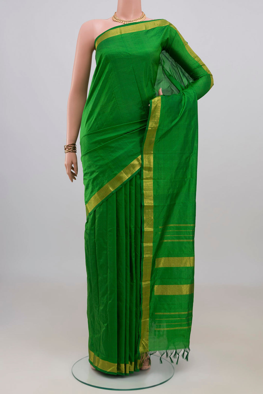 Pure Silk Green Kanjivaram Saree with Plain Body and Zari Border.  displayed on a mannequin