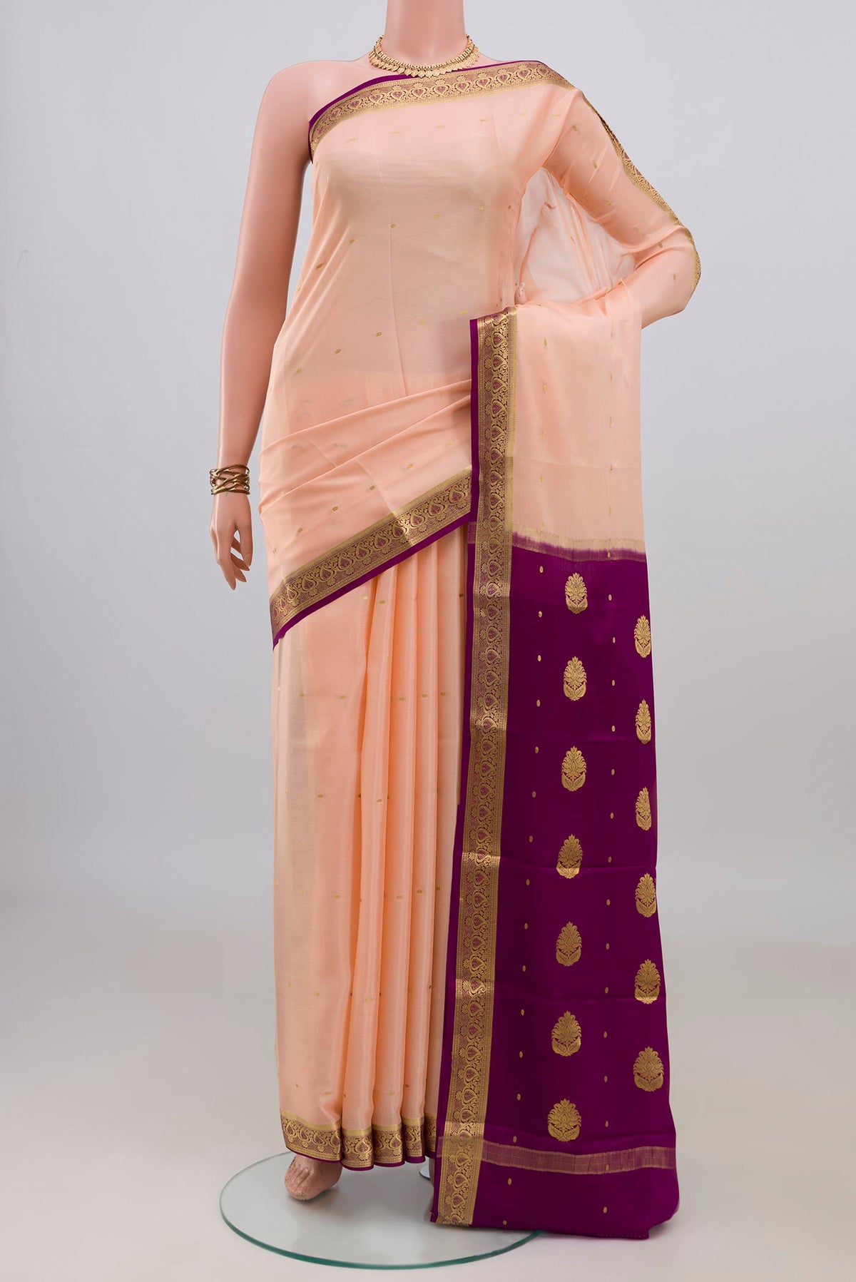 Peach Mysore Crepe Saree with Zari Butta on the body and Zari Border.  displayed on a mannequin