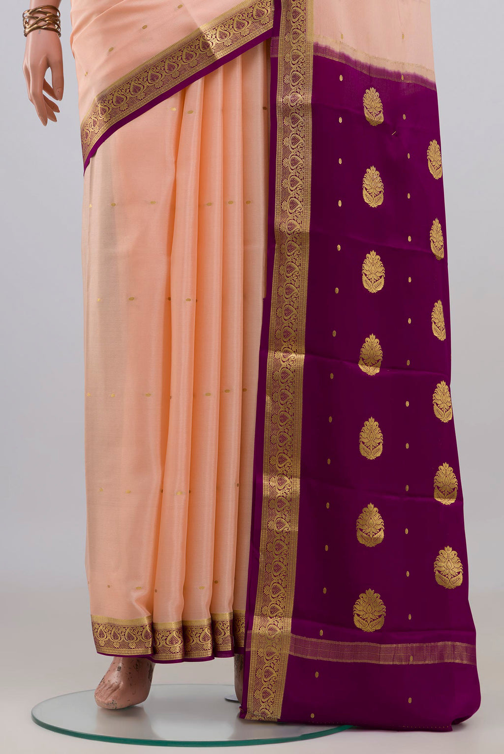 Pleats and pallu of Peach Mysore Crepe Saree with Zari Butta on the body and Zari Border. 