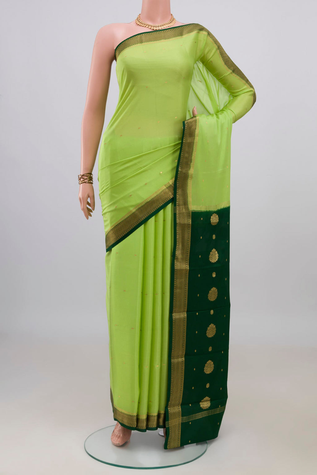 Light Green Mysore Crepe Saree with Zari Butta on the body and Zari Border.  displayed on a mannequin