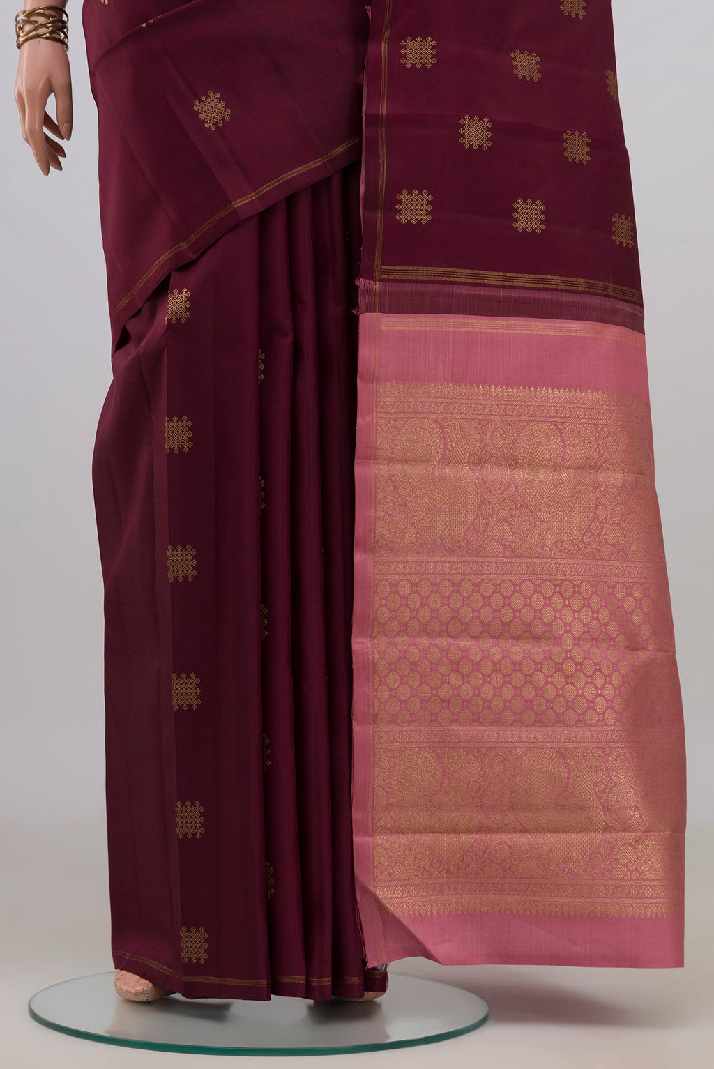 Pleats and pallu of Pure Silk Pure Zari Maroon Kanchipuram Saree with Zari Butta on the body and Thin Zari Line. 
