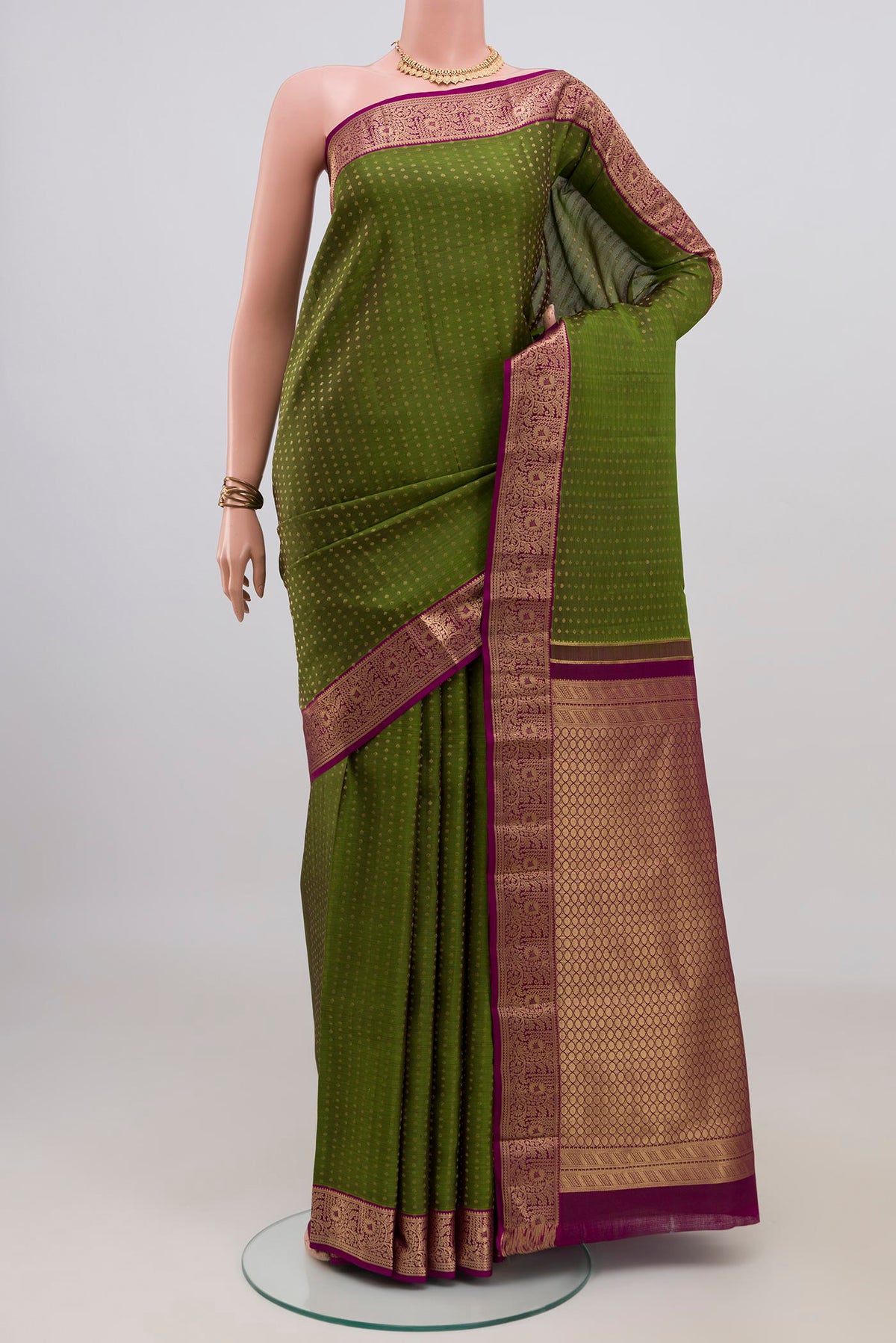 Pure Silk Mehandi Green Kanchipuram Saree with Zari Butta on the body and Zari Border.  displayed on a mannequin