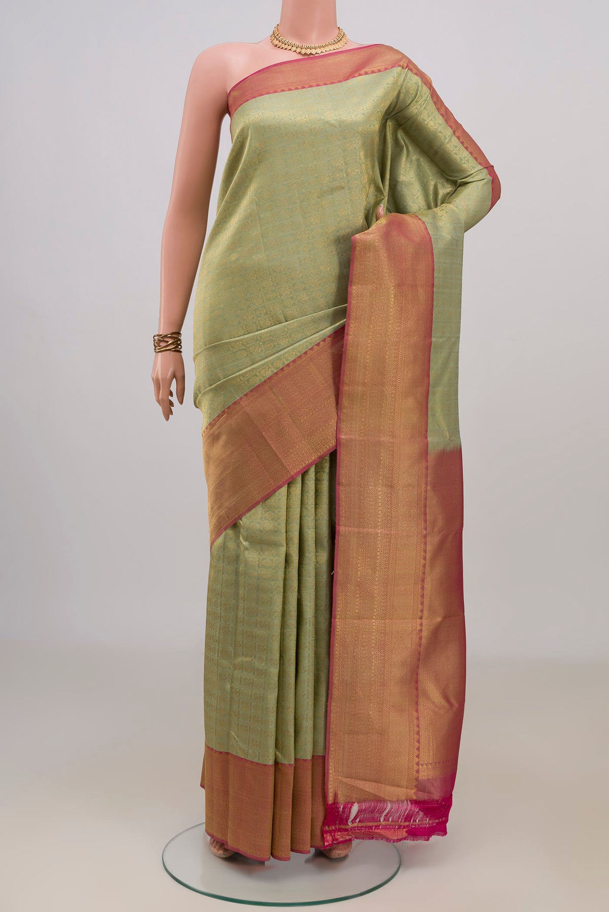 Pure Silk Pista Green Kanchipuram Saree with Zari Brocade on the body and Zari Border.  displayed on a mannequin